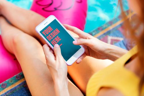 Woman using a mobile phone mockup by the pool - 894814