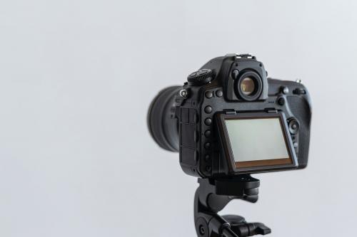 Digital camera on a tripod in a studio - 1225600