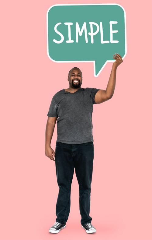 Cheerful man showing word simple in a speech bubble - 477270