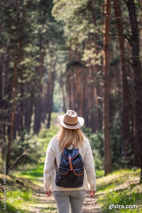 Woman With Hat And Backpack Hiking On Footpath In Forest 6xJPEG