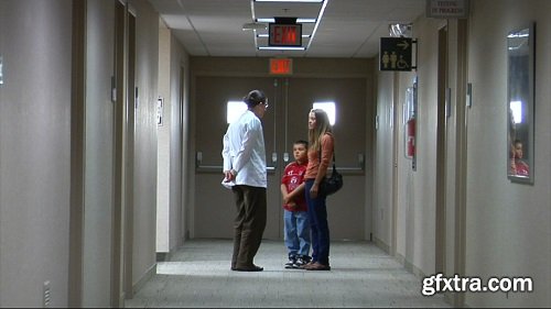 Doctor speaking to mom and son in hallway