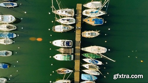 Aerial view of sailboats pier ship dock fly over boats lake water
