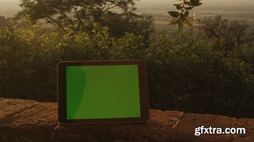 Tablet pc with green screen staying outdoors