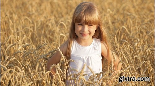 Beautiful little girl standing in wheat smiling and giving thumb up in slow