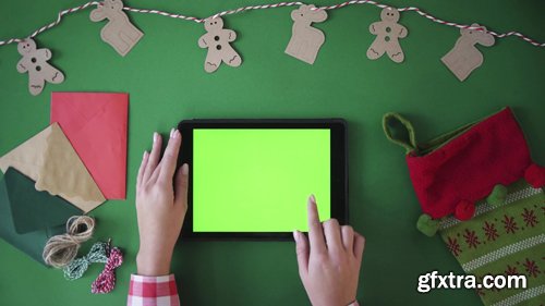 Woman finger swipe images right and left, tapping on green screen of tablet device