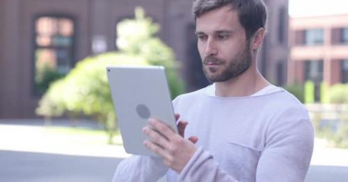 Handsome Man Browsing Internet on Tablet