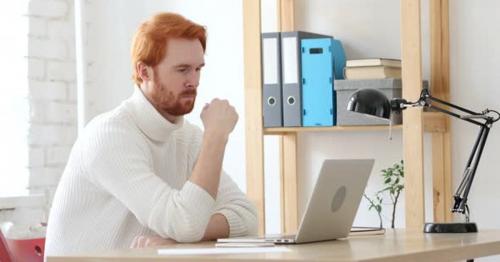 Man with Red Hairs Thinking and Working in His Office
