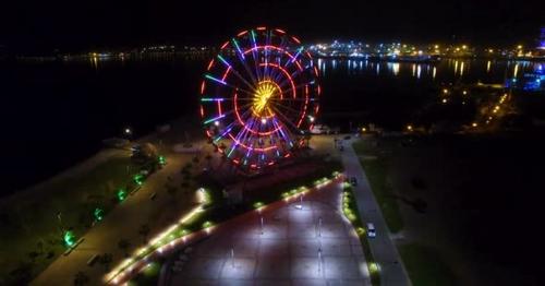 Ferris Wheel Sparking with Lights, Batumi Nightscape Reflecting in Black Sea