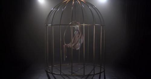 Girl Spinning on a Hoop in a Cage in Dark Studio