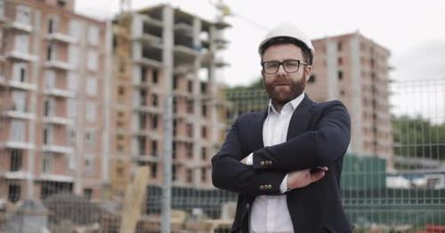 Portrait of Architect Man in Business Suit Standing on the Construction Site with Crossed Hands