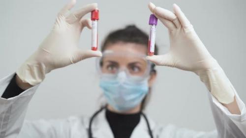 Videohive - Doctor Comparing Blood Samples From Corona Positive Patients at Laboratory - 26218962