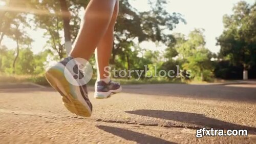 Videoblocks - Girl runs through the park in the morning. Slow motion. Only legs | Footages