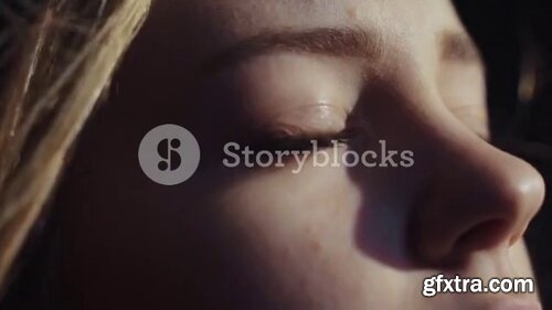 Videoblocks - close up shot face young sensual european girl open blue eyes look brihgt morning sun light deep breathes in new life calm wind atmosphere | Footages
