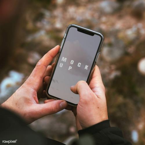 Hands holding a smartphone outdoors mockup - 2097669
