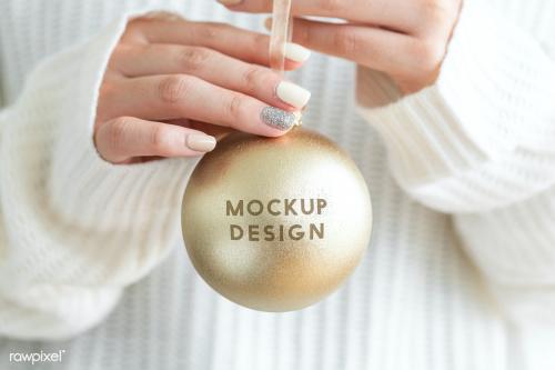 Woman in a white sweater holding a gold bauble mockup - 1231761