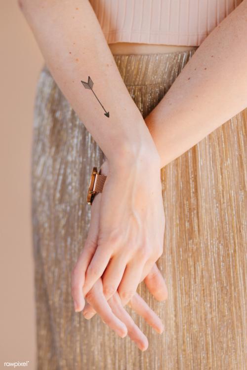 Arrow tattoo on woman's wrist - 1235438
