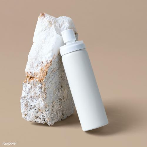White spray bottle psd mockup against a rock - 2053830