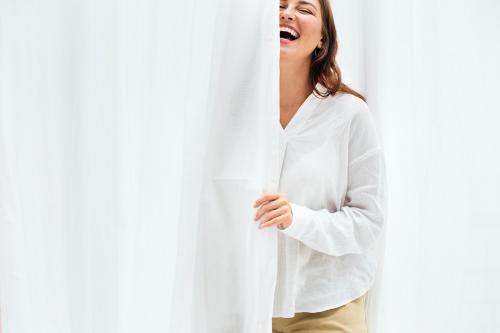 Smiling woman by the white curtain - 1215158