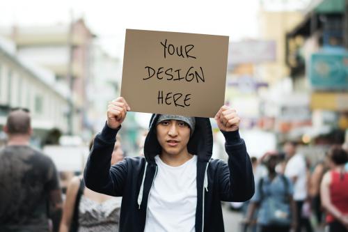 Protester holding a placard mockup outdoors - 894817