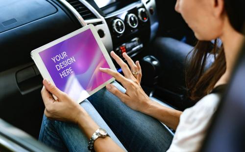 Woman using a digital tablet in a car - 894818
