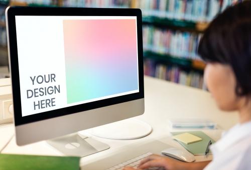 Student in a library using a computer screen mockup - 894857