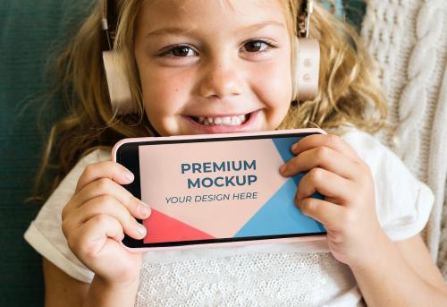 Little girl showing a phone mockup - 580839