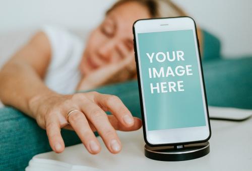 Drowsy woman reaching for a phone mockup - 580921