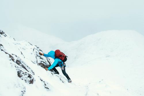 Mountaineer using an ice axe to climb Forcan Ridge in Glen Shiel, Scotland - 2221629