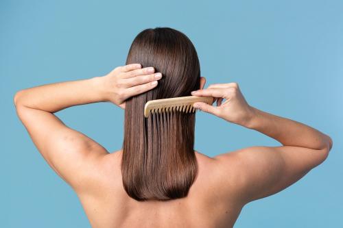 Woman combing her sleek hair - 2230339