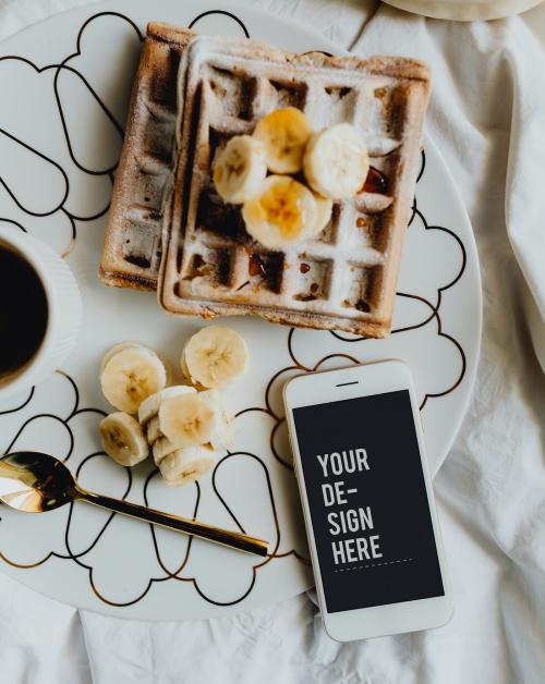 Plate of waffle with slices of banana and a cup of coffee next to a smartphone - 540868
