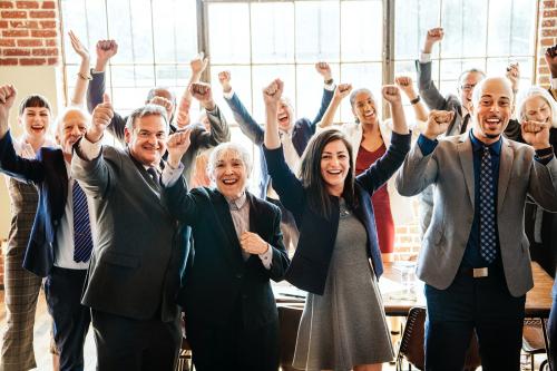 Cheerful businesspeople raising hands in the air - 2020159