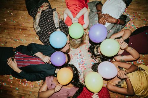 Friends lying on the floor at a party with balloons - 2097309
