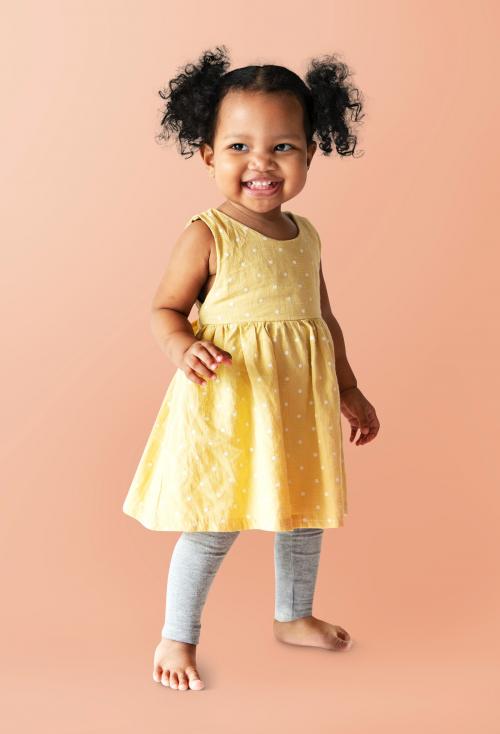 Happy little girl in a yellow dress standing - 536111