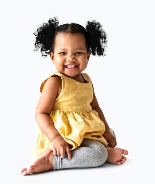 Happy little girl in a yellow dress sitting - 536116