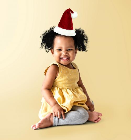 Happy little girl in a yellow dress with a Christmas hat - 536134