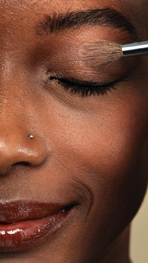 Makeup artist applying eye shadow on a black woman - 2249975