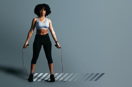 African American woman standing holding skipping rope - 2111145