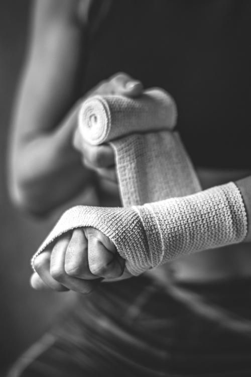 Female boxer putting a strap on her hand - 2114592