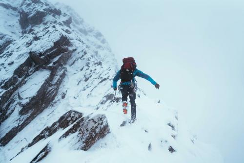 Mountaineer using an ice axe to climb Forcan Ridge in Glen Shiel, Scotland - 2221680