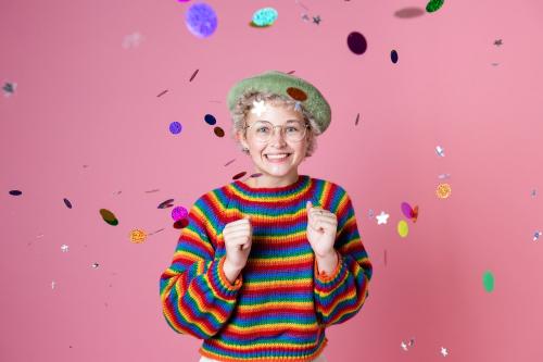 Studio portrait of a girl wearing glasses in a confetti in a pink background - 2223243