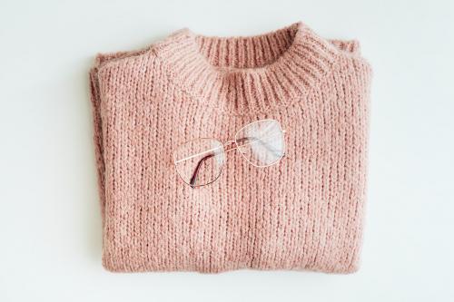 Flat lay of glasses on a pink knitted sweater - 2254083