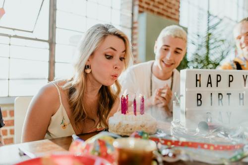 Blowing out the candles on a birthday cake - 2097462