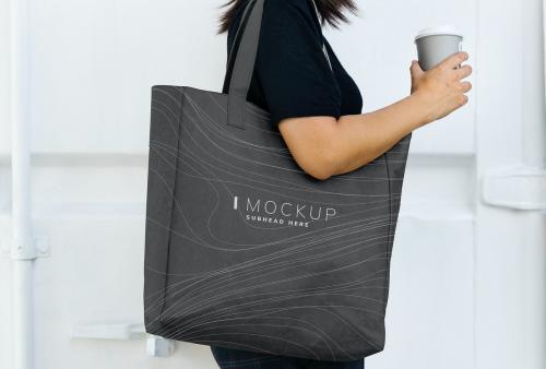 Woman carrying a black shopping bag mockup - 502939