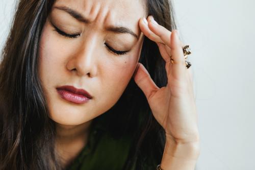 Stressed woman holding her forehead - 2030342