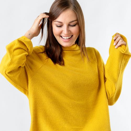 Cheerful woman wearing a mustard yellow sweater - 2296494