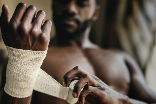 Male boxer putting a strap on his hand - 2114593
