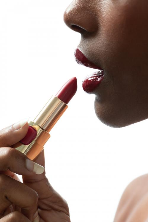 Black woman applying red lipstick on her lips - 2254268
