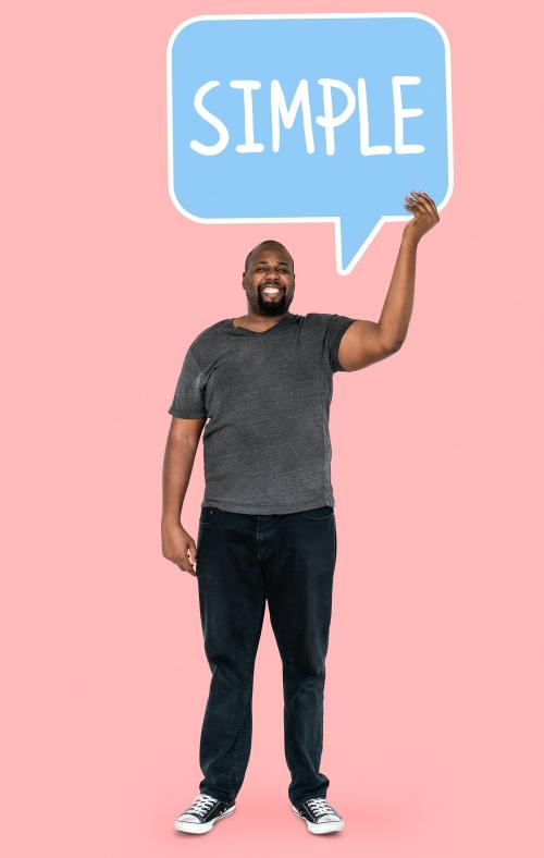 Cheerful man showing the word simple in a speech bubble - 492426