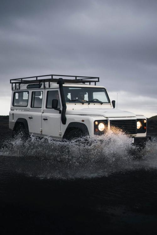 Land Rover crossing the puddle on the dirt road - 2042728