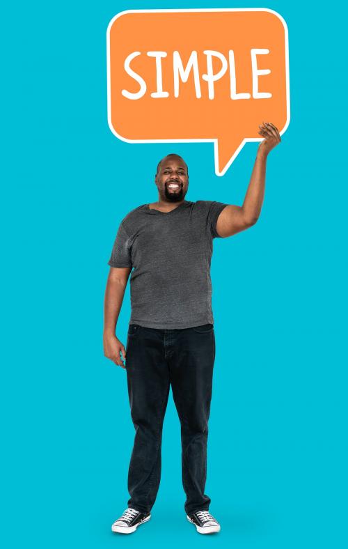 Cheerful man showing the word simple in a speech bubble - 492158